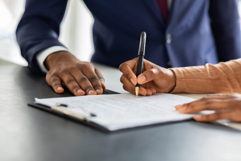 Deux professionnels africains discutant d'un contrat de travail en RDC dans un bureau moderne à Kinshasa