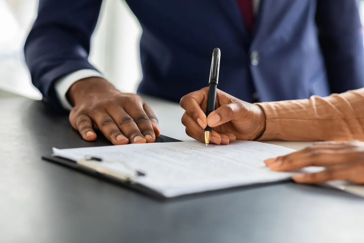 Deux professionnels africains discutant d'un contrat de travail en RDC dans un bureau moderne à Kinshasa